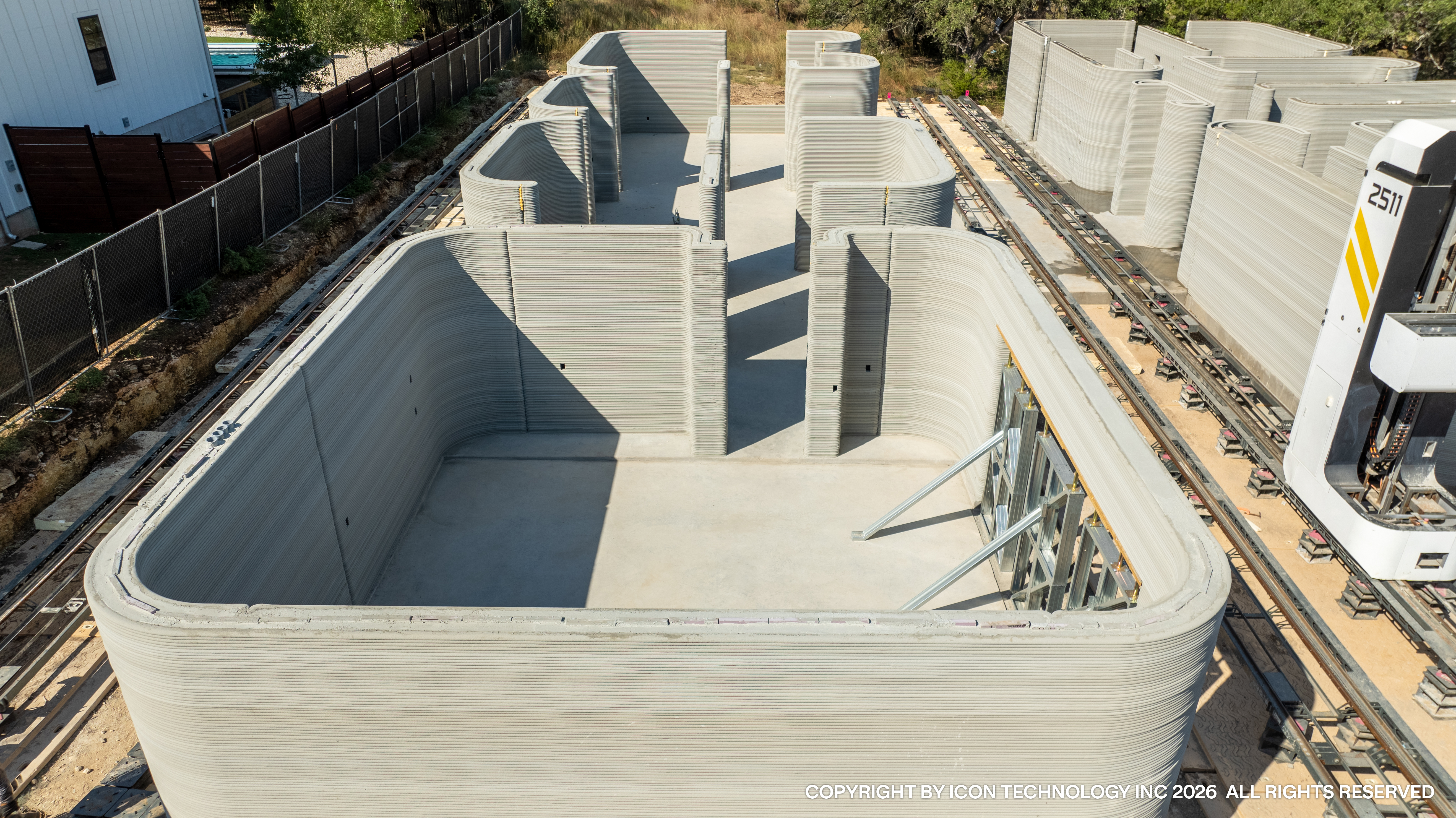 Finished 3D printed concrete home exterior at Wolf Ranch showing the layered concrete wall surface