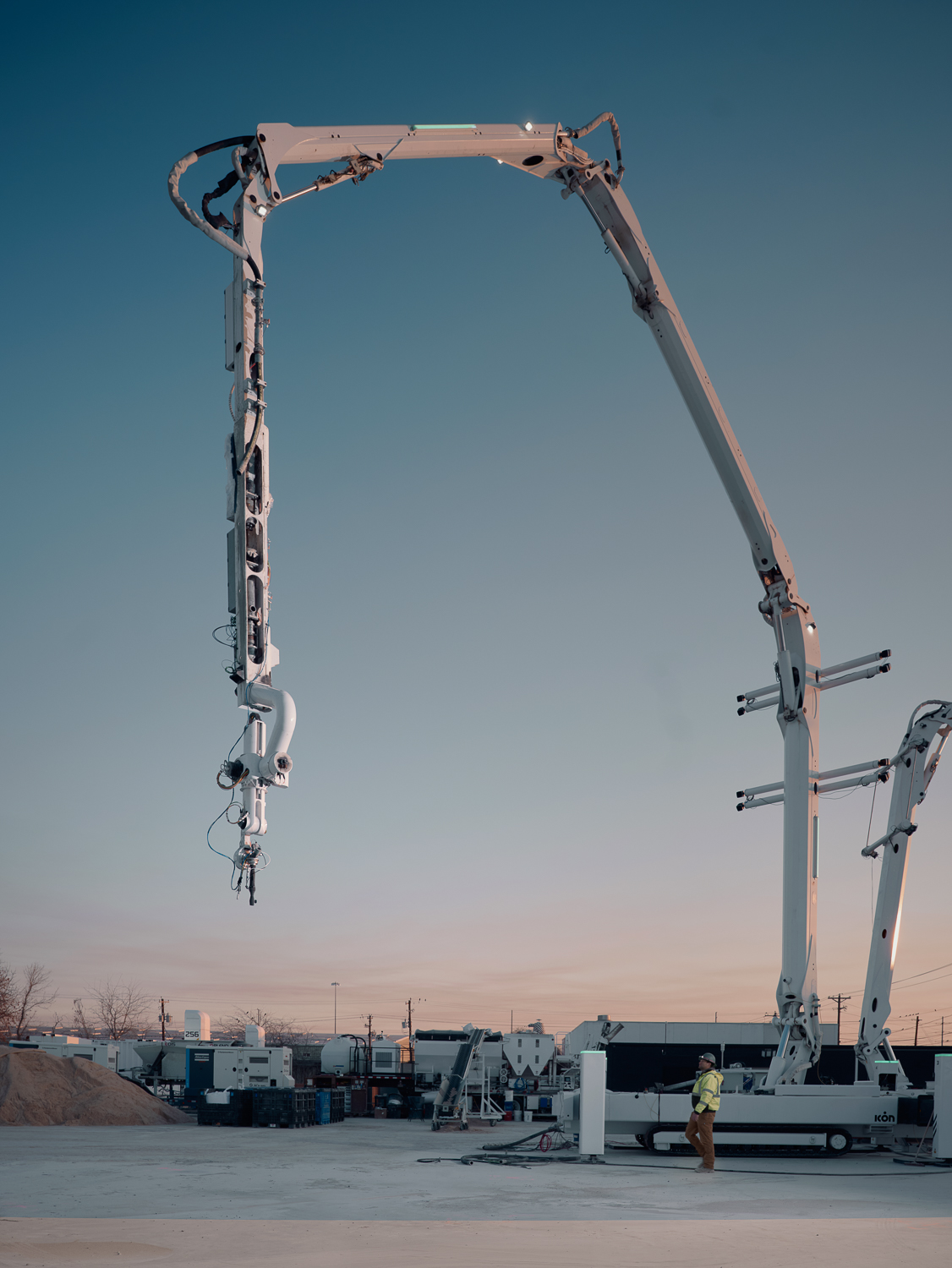 ICON Titan robotic gantry printer at sunset on an active 3D concrete printing job site